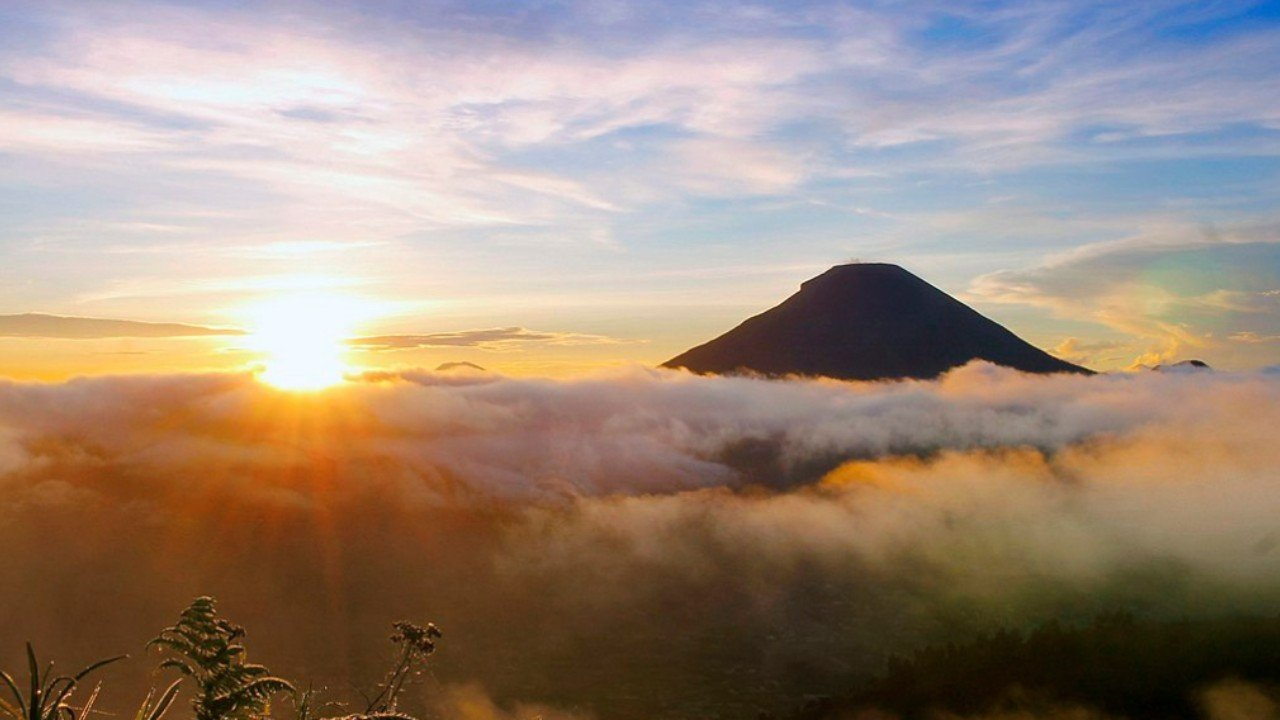 golden sunrise dari Bukit Sikunir dengan langit keemasan