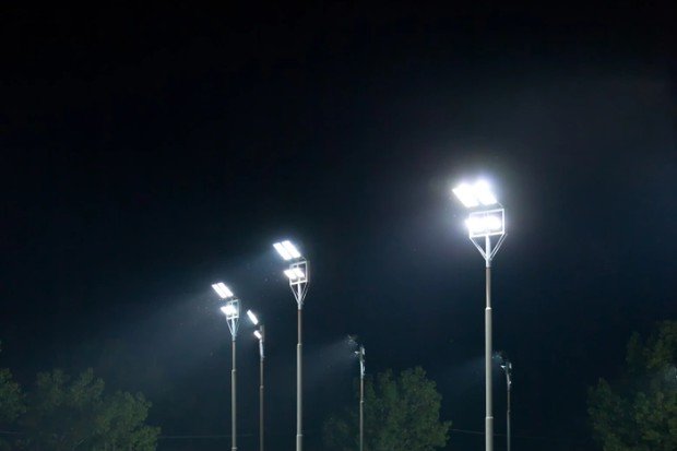 Lampu sorot menerangi halaman rumah pada malam hari